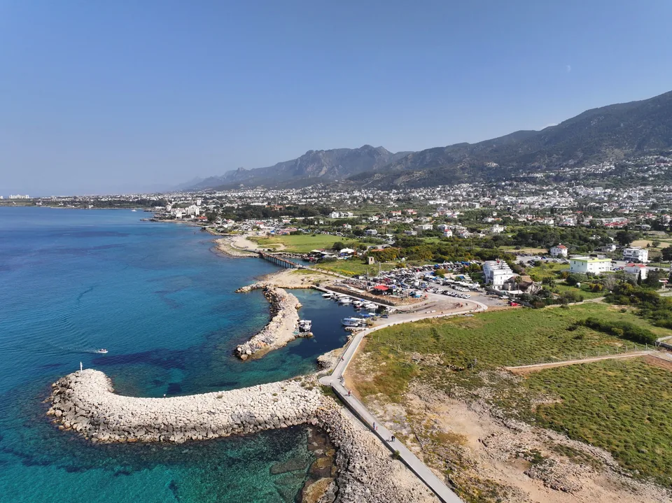 Alsancak kıyısı, balıkçı barınağı ve Beşparmak Dağları, havadan görünüm